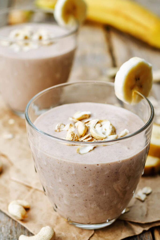 Image of a chocolate banana oat smoothie recipe with a banana next to the drink