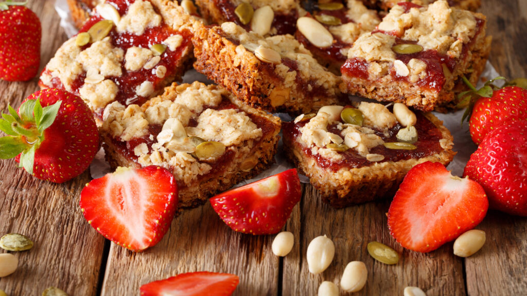 Image of granola bars spread with jam and sprinkled with nuts and seed: healthy snacks for work