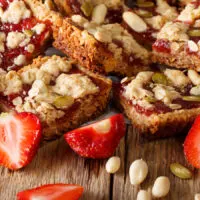 Image of granola bars spread with jam and sprinkled with nuts and seed: healthy snacks for work