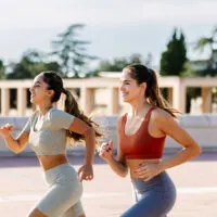 Image of 3 friends running together outdoors.