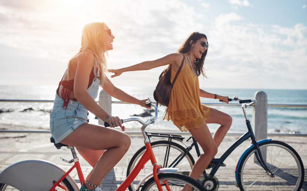 Image of two women riding bikes and having fun in the sunshine