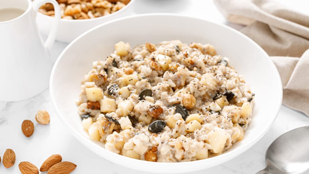 oatmeal bowl with chopped apple, nuts, chia and pumpkin seeds