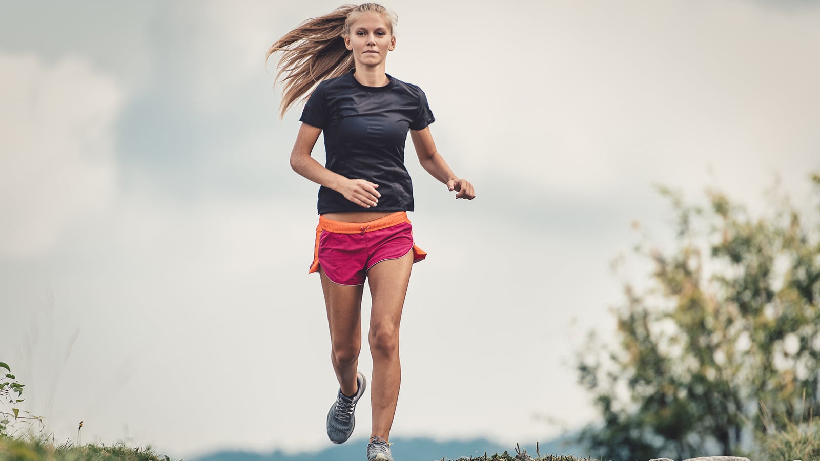 Image of a young female runner completing a hill repeat workout