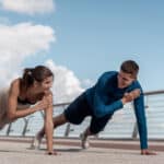 A young couple doing plank tap exercises together