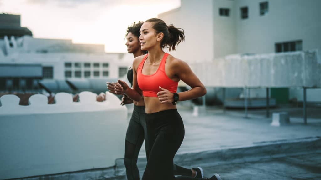 Image of two female friends running