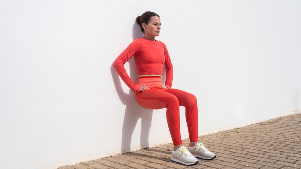 Image of a woman doing a wall sit as part of knee strengthening exercises