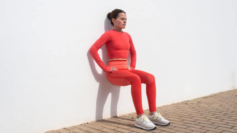 Image of a woman doing a wall sit as part of knee strengthening exercises